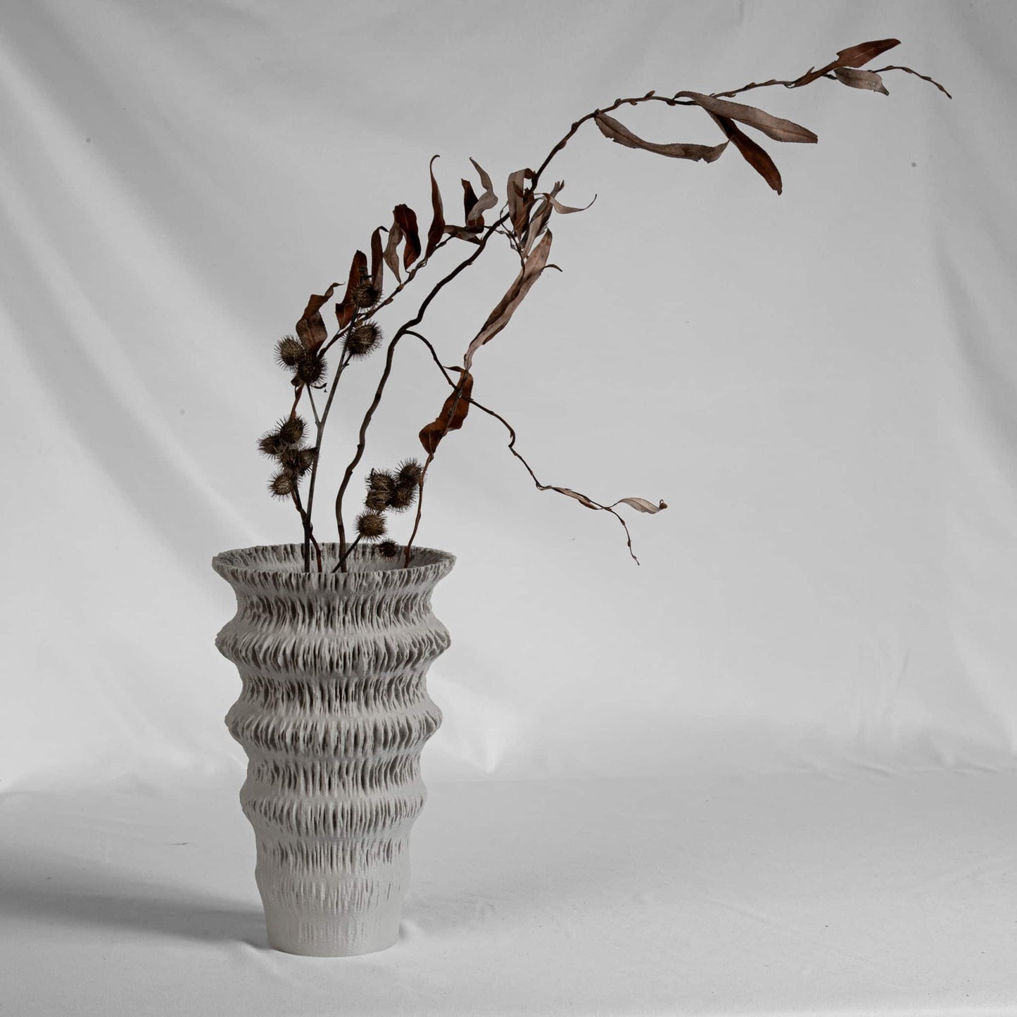 3d printed modern vase FLUVIA on wooden shelf with dried branches