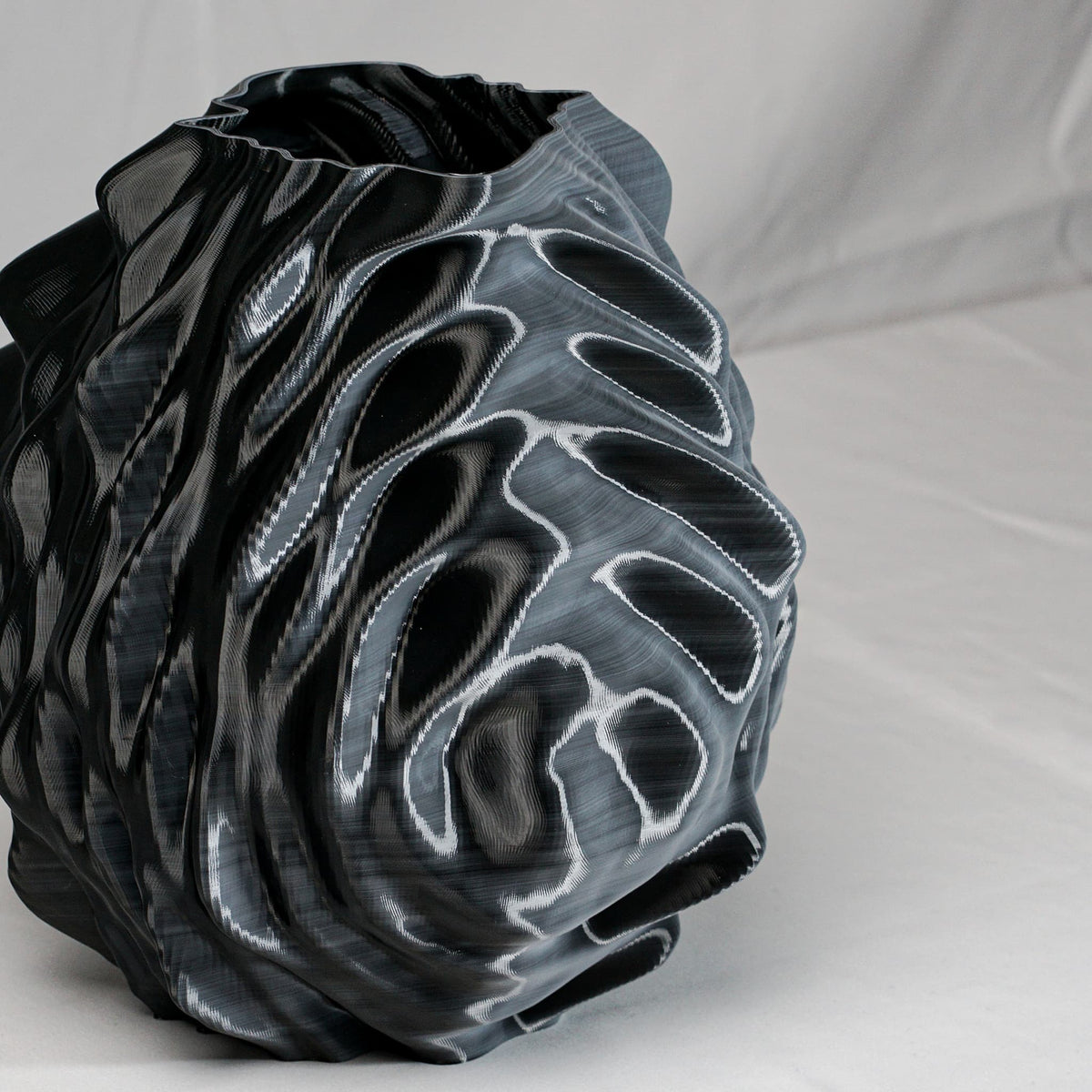 Black and gray textured vase on a light gray background