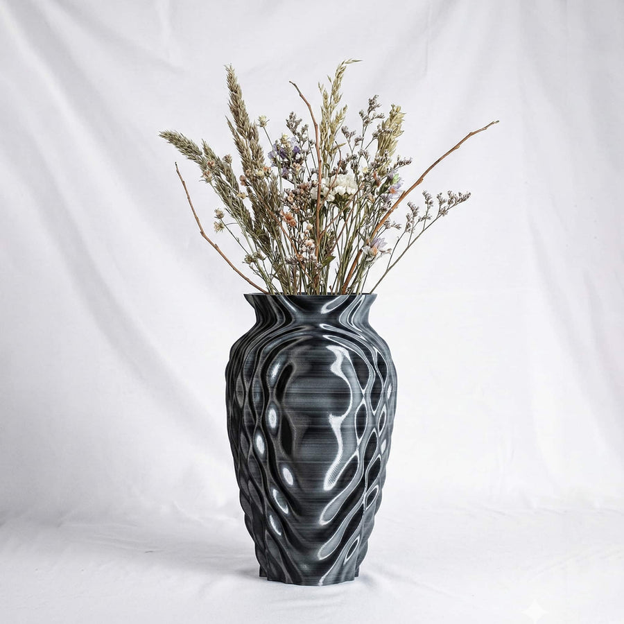 The ONDA Resonance vase holding a bunch of pale dried flowers, on a white ground