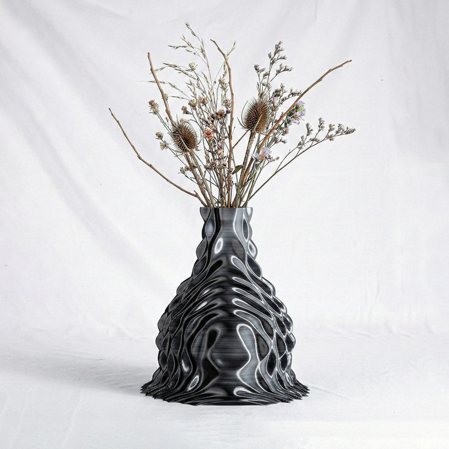 The ONDA Diffraction vase holding a composition of dried flowers, on a white ground