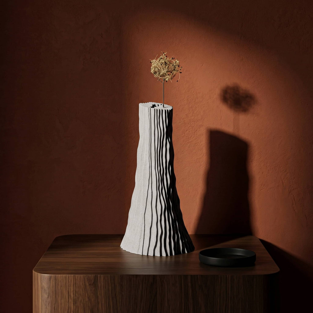 Carsia vase on a dark wood surface and brown red wall on background