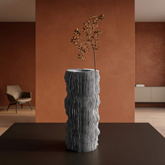 Profilum vase with a flower inside his folds on a table with a orange brown background wall