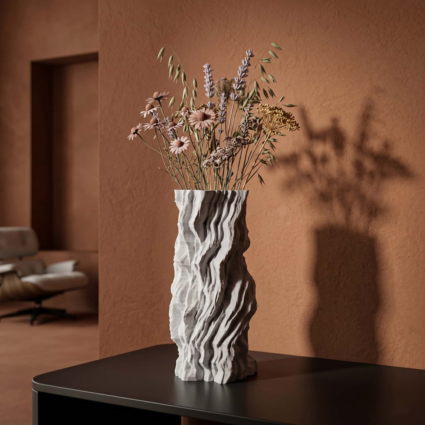 Telluria vase with rock pattern on a table against a warm-toned wall.